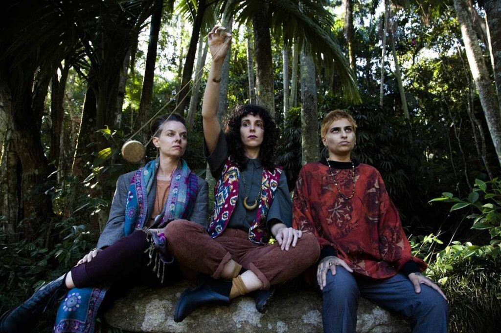 Imagem com as três integrantes da banda Ema Stoned em uma floresta