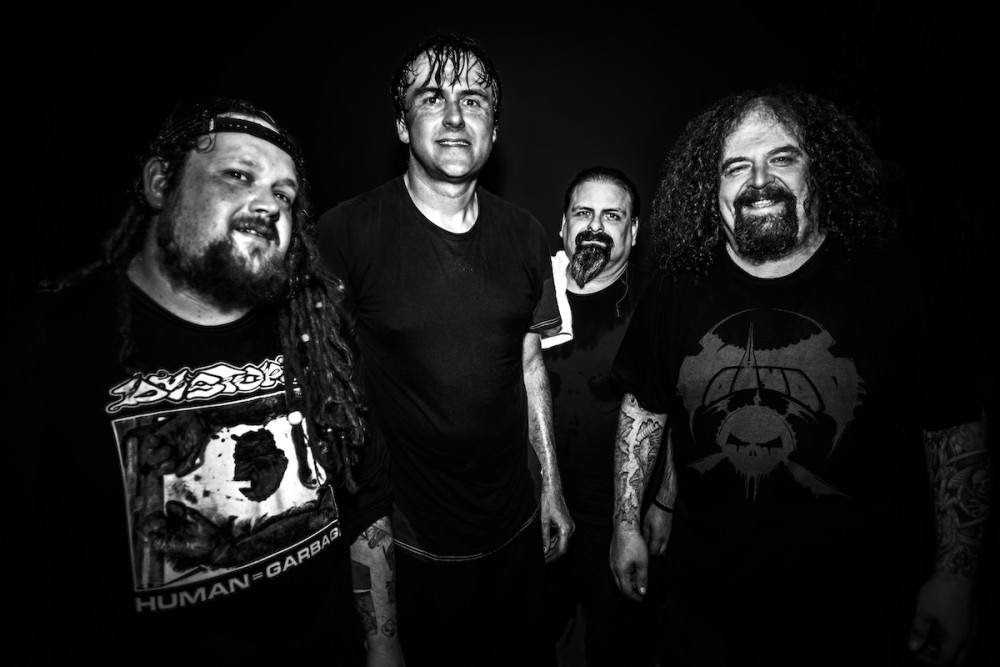 Imagem em preto e branco com os quatro integrantes da banda Napalm Death