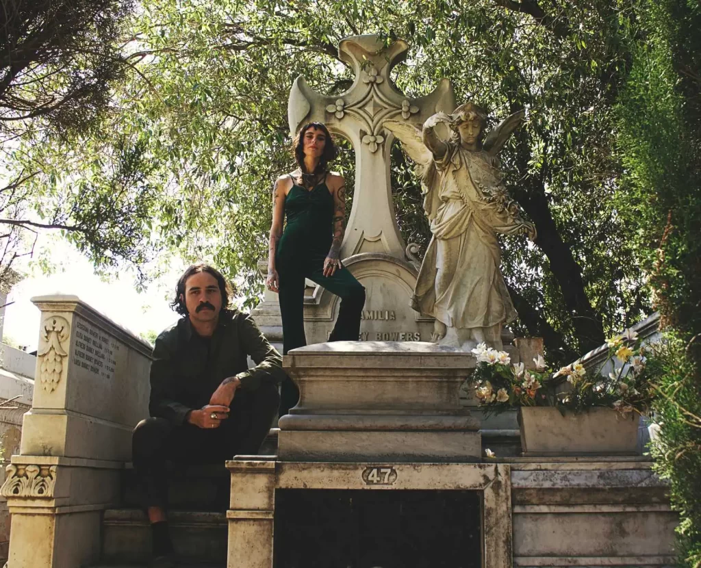 Imagem de dois integrantes da banda White Canyon and the 5th Dimension em frente a uma sepultura